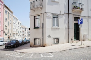 A street with parked cars and a building with a 'P' parking sign.
