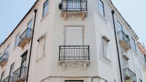 Un immeuble à plusieurs étages, doté de balcons, de fenêtres et d  ’un sol pavé.