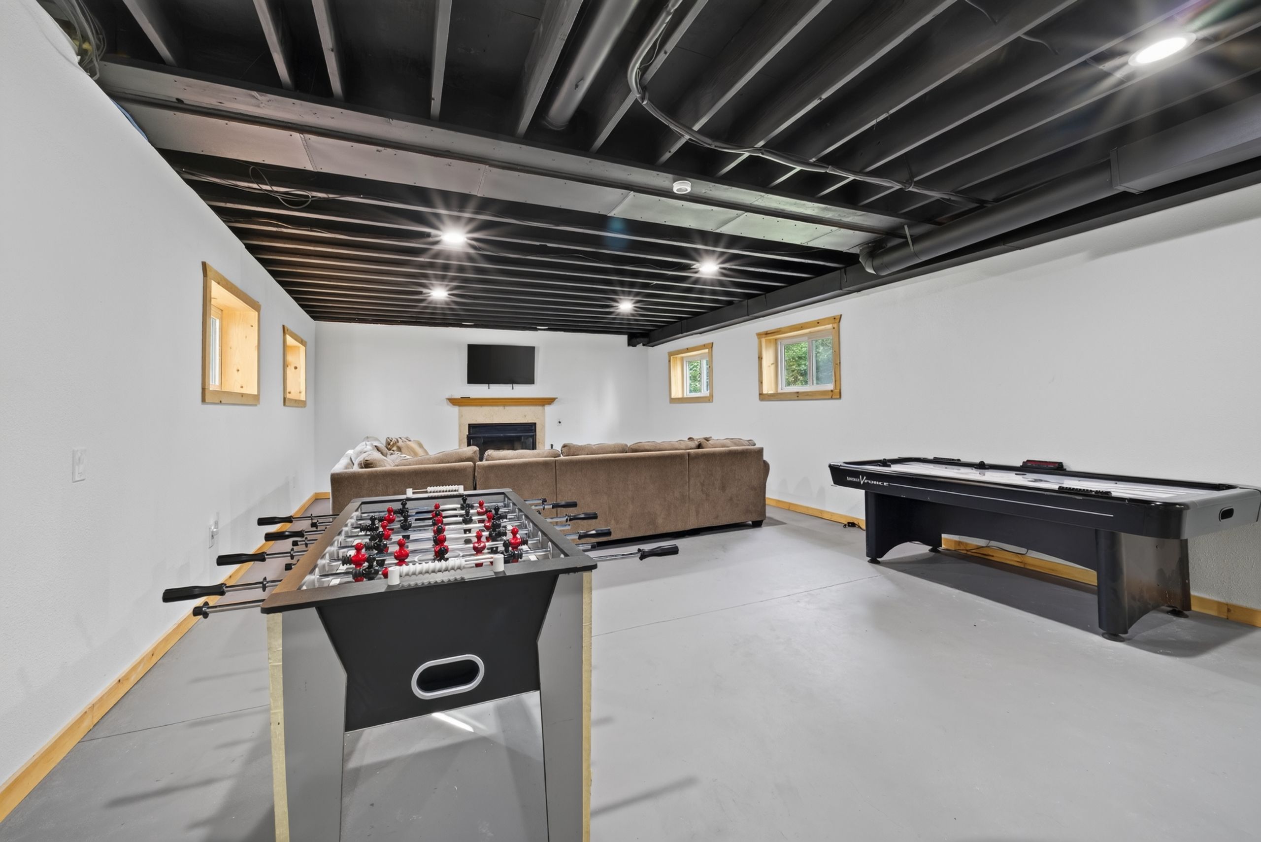 Une pièce équipée d’un baby-foot, d’une table de billard et d’un canapé.