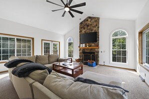 A spacious living room with a large sofa, a coffee table, and a fireplace.
