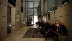 A modern lobby with a leather sofa, a coffee table, and a decorative floor rug.