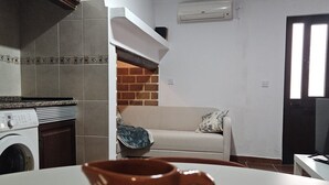 Une cuisine équipée d’un lave-linge, d’une machine à café et d’une cheminée en briques.