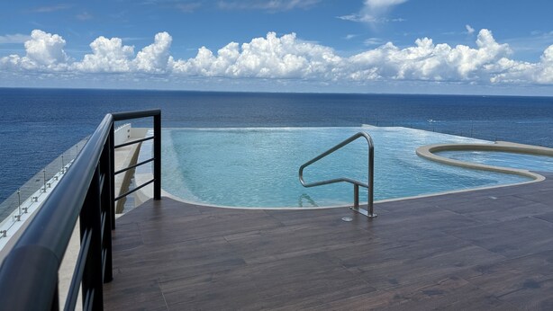 A pool with a view of the ocean and a clear sky. - Newly Luxury Condo in Cozumel! D'Maria Condos (Cozumel)