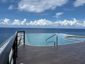 A pool with a view of the ocean and a clear sky. - Newly Luxury Condo in Cozumel! D'Maria Condos (Cozumel)