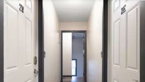 Un pasillo con puertas blancas, cada una con un número.