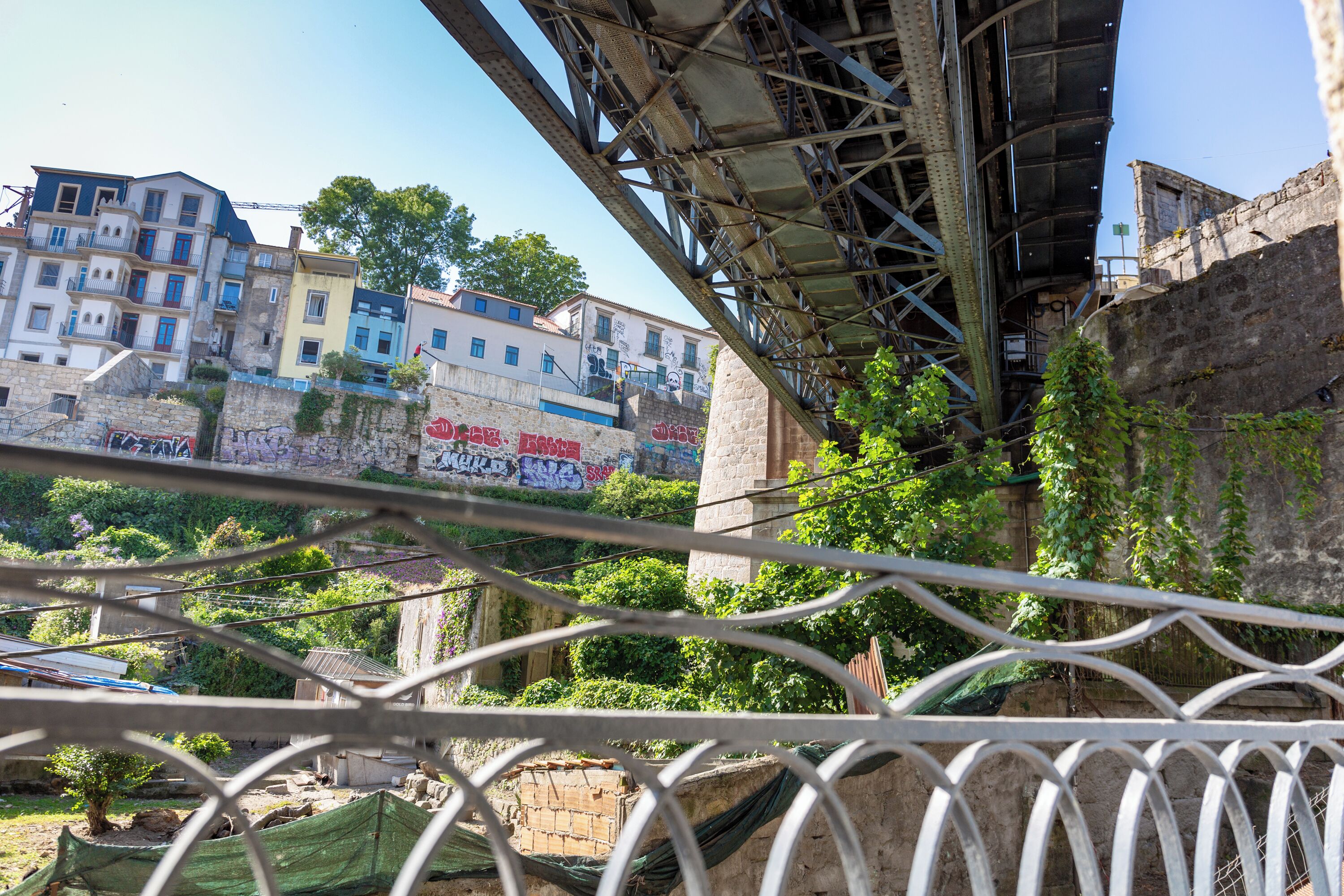 A view of a bridge with metal railings and a cityscape in the background.
