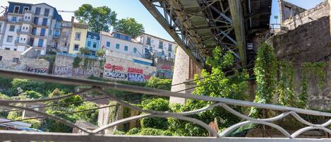 A view of a bridge with metal railings and a cityscape in the background.