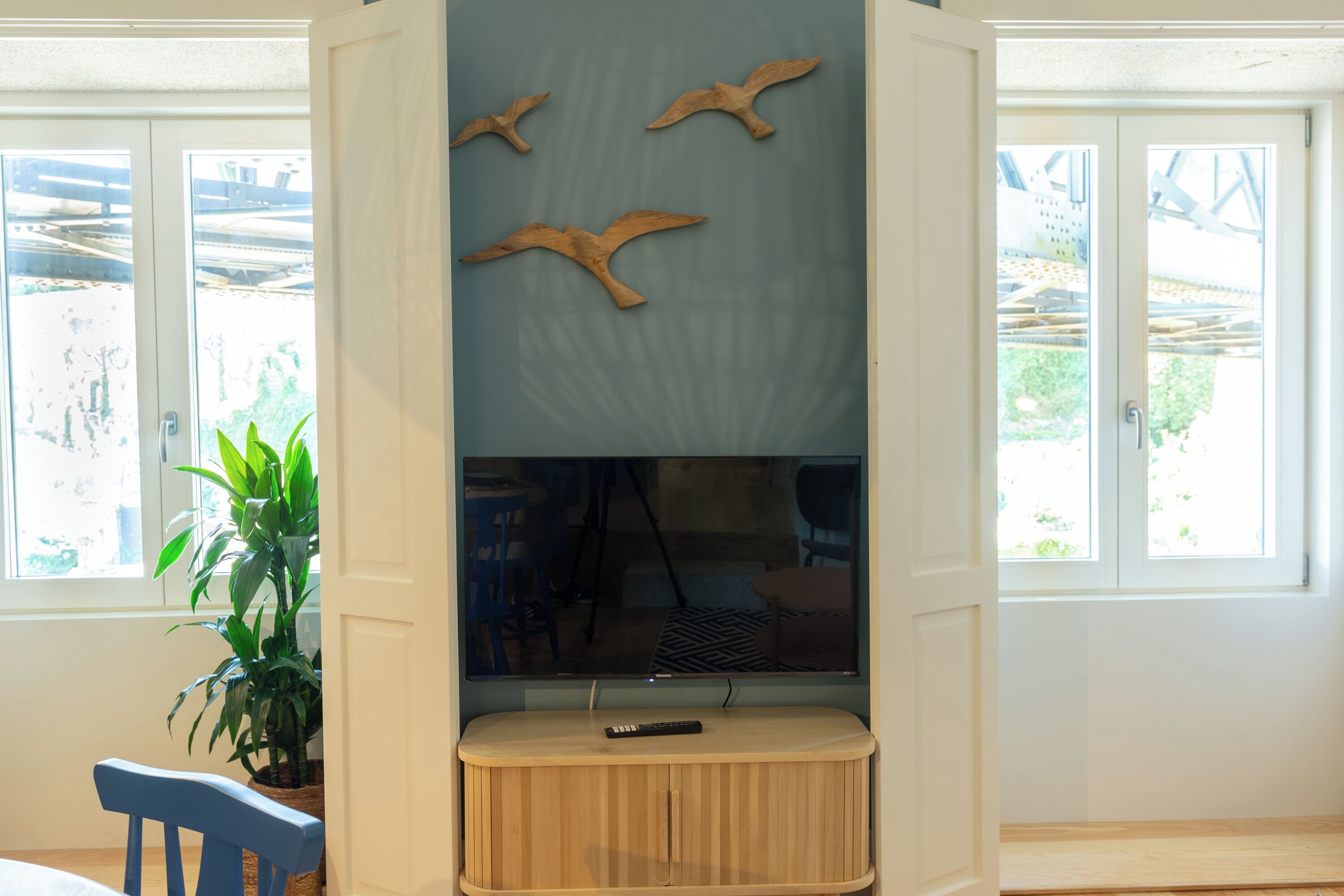 Una habitación con una unidad de entretenimiento de madera, un televisor y una planta en maceta.