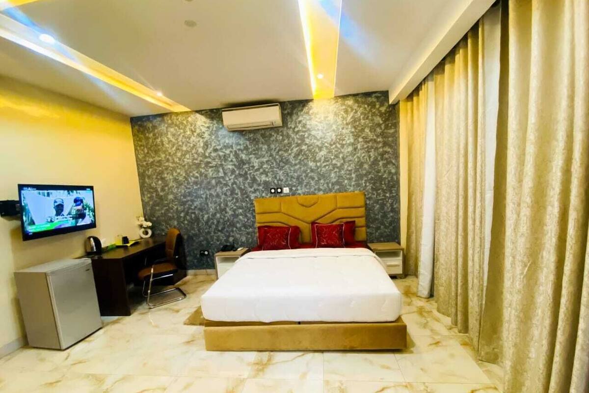 Ein Hotelzimmer mit einem Bett, einem Schreibtisch, einem Fernseher und einer Klimaanlage.