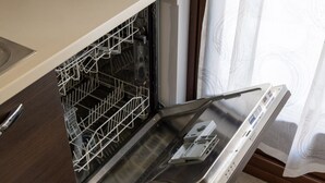 Dishwasher oberta amb interior d'acer inoxidable i panell de control a la dreta.