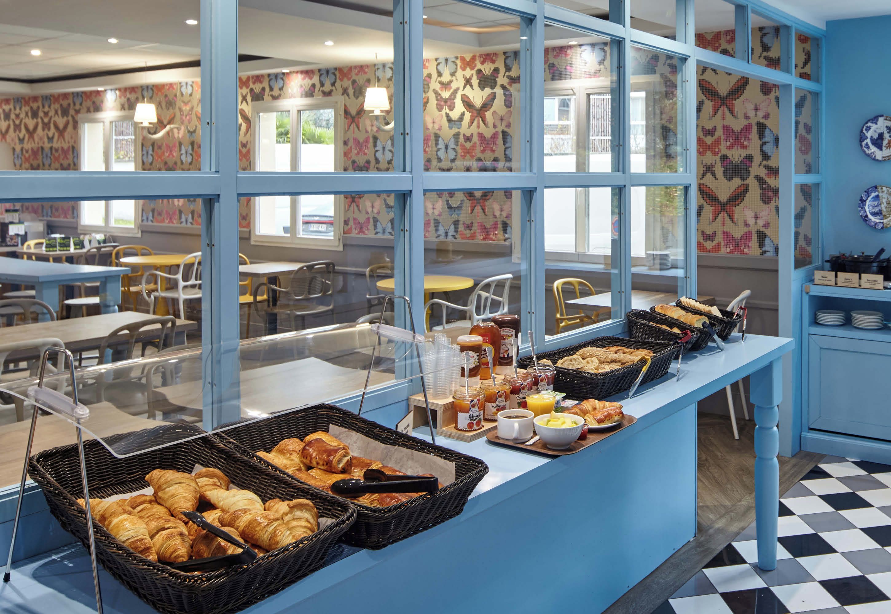 A breakfast buffet with croissants, pastries, and beverages.