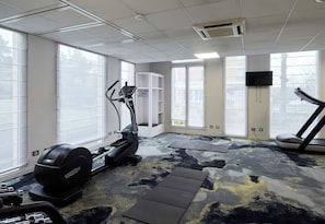 A gym with treadmills, a stationary bike, and a weight machine. - B&B Hotel Saint-maur Créteil (Saint-Maur-des-Fosses)
