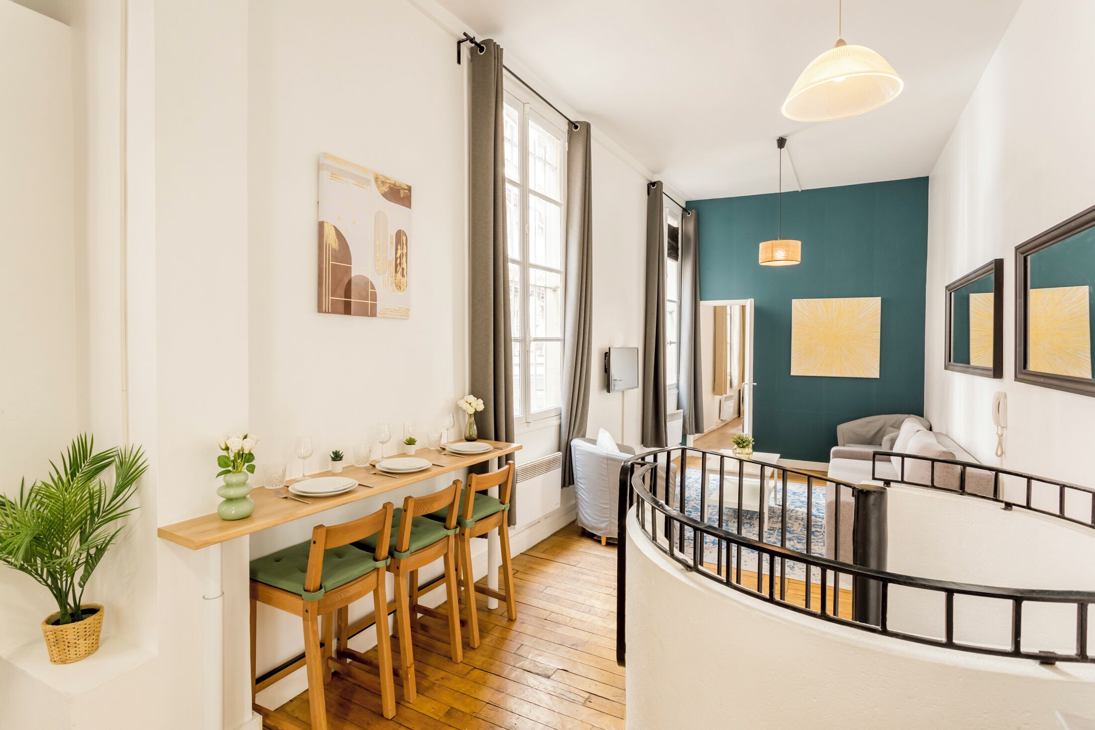 A dining area with a wooden table, chairs, and a potted plant.