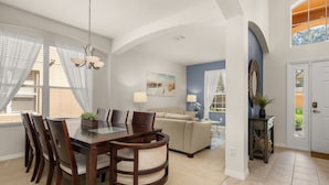 A spacious living room with a dining area, a sofa, and a chandelier. - ⭐⭐Spacious 6 bed Home | Gated Resort | Netflix Den | PS5 | Conservation View⭐⭐ (Davenport)