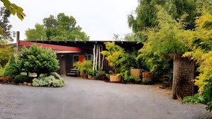 A building with a red roof, surrounded by various trees and shrubs. - Gîte Dilos – Holiday Home in Gan (Gan)