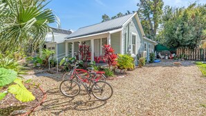 A house with a gravel driveway, a bicycle, and a variety of plants.