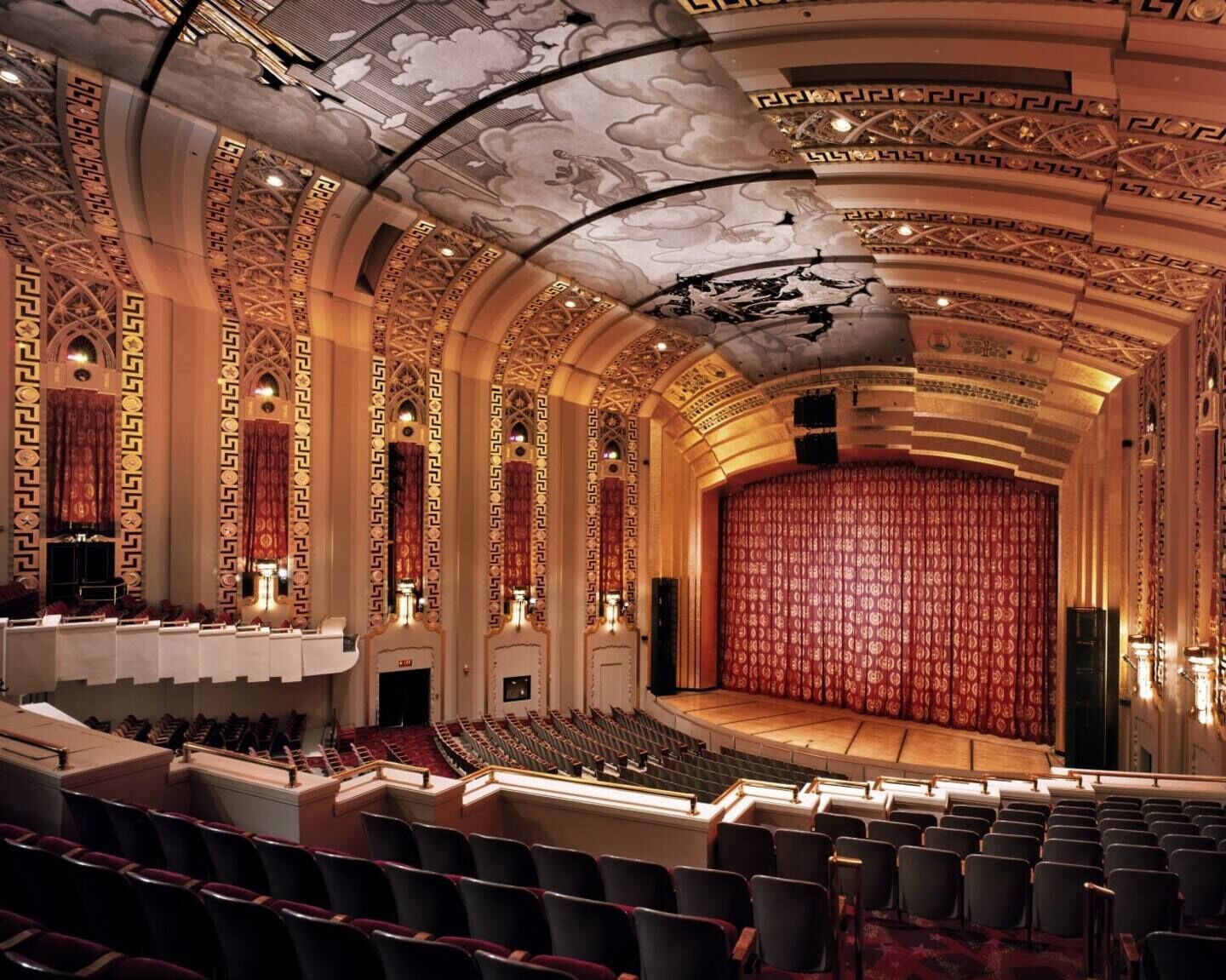 Un teatro con techo ornamentado y asientos.