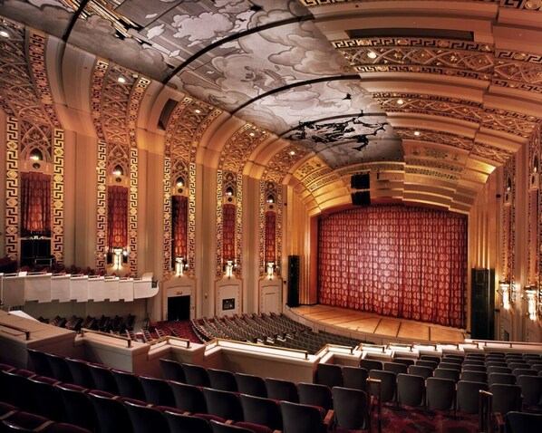 A theater with ornate ceiling and seating.