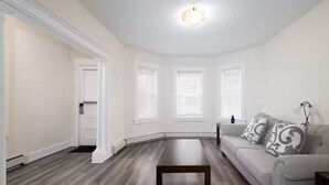 A spacious living room with hardwood flooring, a sofa, and a coffee table. - Spacious Urban Townhouse • Groups and Family (Hartford)