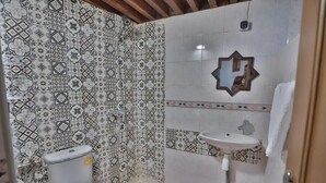 A bathroom with patterned tiles, a toilet, a sink, and a mirror. - Dar Fes Flores  (Fes)
