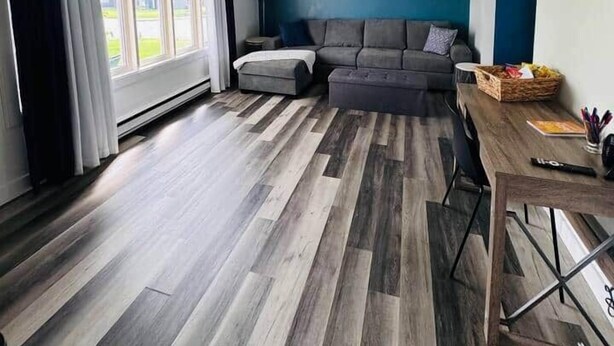 Una sala de estar moderna con sofá, reposapiés y una mesa de comedor con sillas.