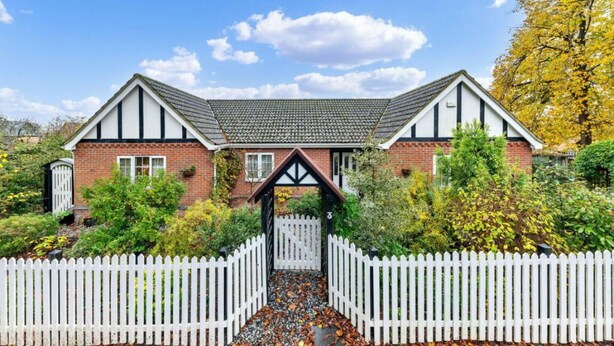 A two-story house with a white picket fence, a brick exterior, and a tiled roof. - Sizeable 4 bed property on Huntingdon Ring road (Huntingdon)
