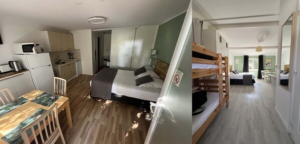A compact room with a bunk bed, a kitchenette, and a dining area.