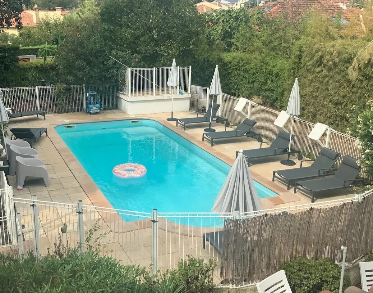 Een seizoensgebonden buitenzwembad en parasols bij het zwembad