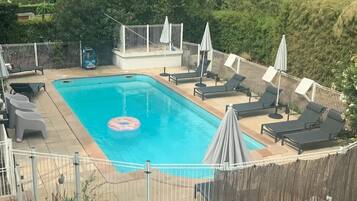 Een seizoensgebonden buitenzwembad en parasols bij het zwembad