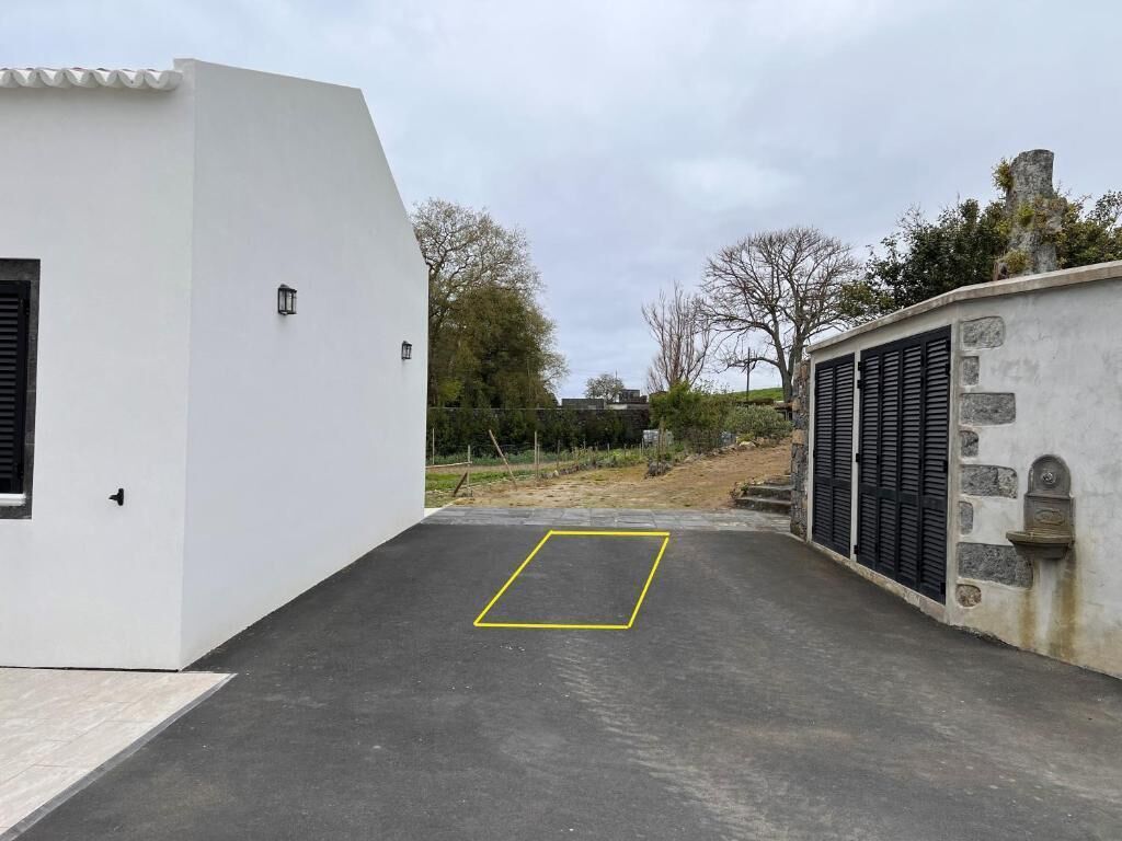 Un edificio moderno con techo plano y camino de entrada pavimentado.