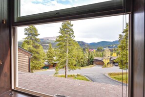 Bairro residencial com casas, entrada de automóvel e vista para a montanha.
