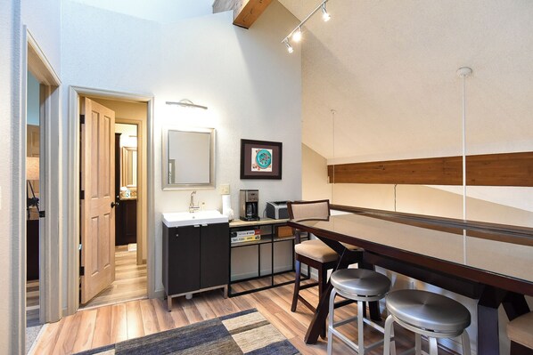 A modern bathroom with a sink, mirror, and a framed picture on the wall.
