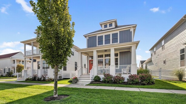 A two-story residential building with a front porch, a small tree, and a well-maintained lawn. - Harbor Shores 3BR in St. Joseph | Community Pool, Sleeps 8, Near Silver Beach (St Joseph)