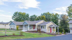 A row of single-family homes with front porches, stone foundations, and a well-maintained lawn. - 8 mins to Lake Monroe • Grill • Firepit • By IU (bloomington)