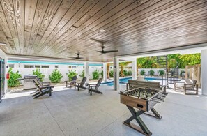 An indoor recreational area with a pool, lounge chairs, and a foosball table. - New 8/8 bathroom beach house! Heated pool and spa! (Sarasota)