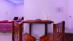 A room with a bed, a table with a bowl of fruit, and a chair. - Studio 'Luci's House B' with Mountain Views, Shared Terrace, and Wi-Fi (São Jorge santana)