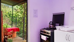 A kitchen with a gas stove, a kettle, and a white cabinet. - Studio 'Luci's House B' with Mountain Views, Shared Terrace, and Wi-Fi (São Jorge santana)