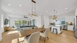 A modern kitchen with a central island, wooden flooring, and pendant lighting. - Sleeps 44, Luxury Compound, 2 Pools, 2 Kitchens (Austin)