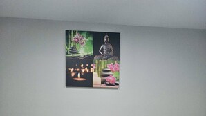 Ein stilvolles Wohnzimmer mit grauem Sofa, schwarzen Kissen, einer weißen Decke und einem dekorativen Gemälde darüber.