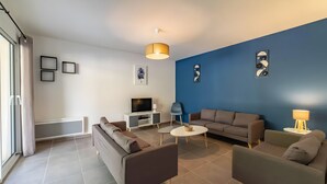 A modern living room with a sofa, armchairs, a TV, and artwork on the walls. - Villa 'Gite Les Bouches Rouges 6 Personnes' with Mountain View, Wi-Fi and Air Conditioning (Vesseaux)