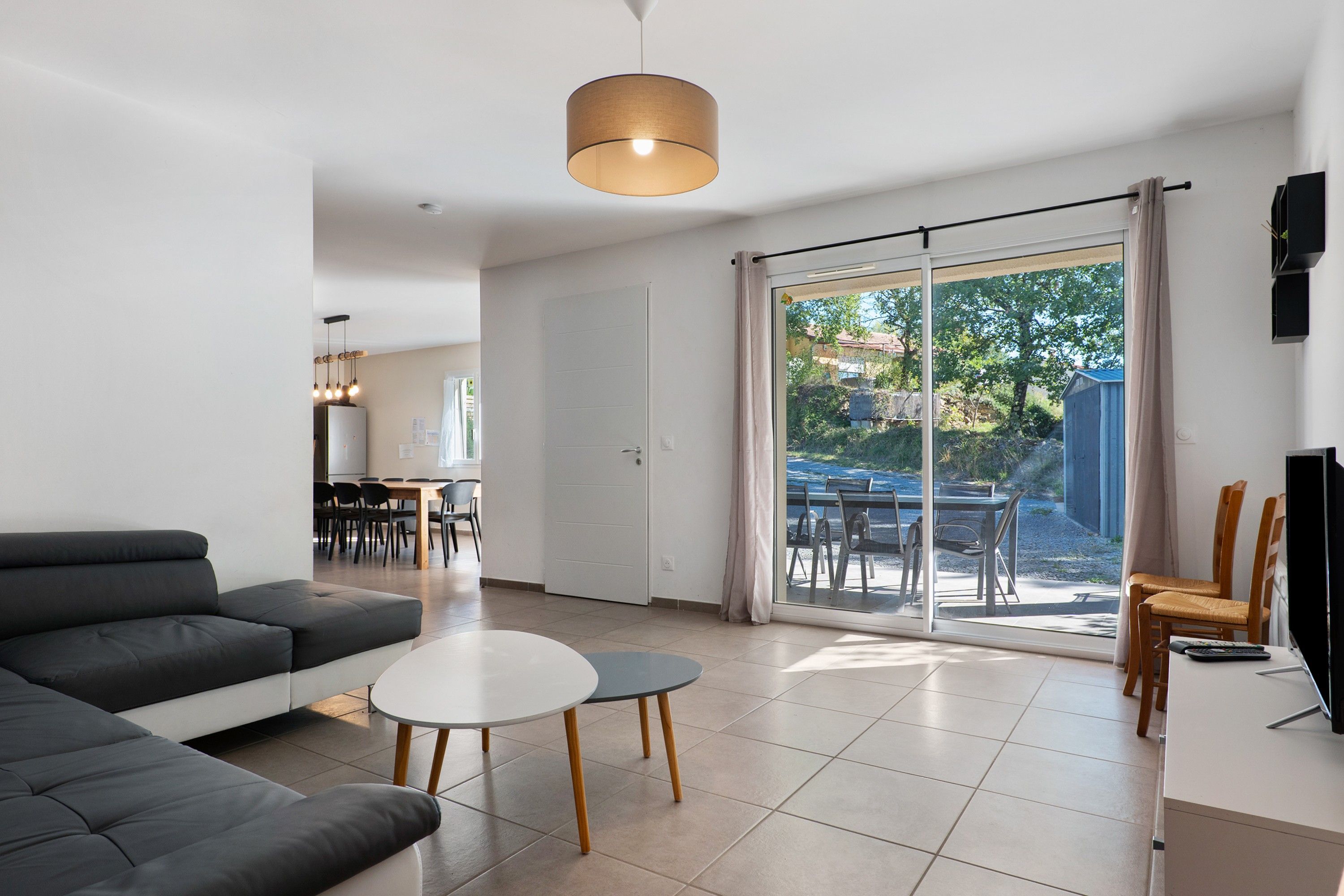 A modern living room with a sofa, a small round table, and a TV.