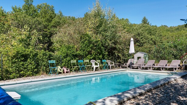 A swimming pool with lounge chairs and a small pavilion. - Villa 'Gite Les Bouches Rouges 6 Personnes' with Mountain View, Wi-Fi and Air Conditioning (Vesseaux)