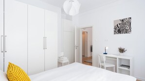 Une chambre à coucher moderne, avec un lit, un bureau et une armoire.