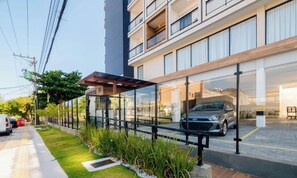 A modern building with a covered outdoor seating area, a car parked in front, and a clear sky. - Fully Equipped Apartments in a Building With a Pool and Gym, 280m From the Beach - Clfs (Salvador)
