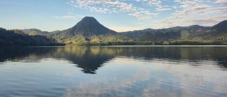 A calm lake with a mountain in the background and a clear sky.