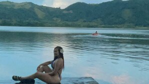 A wooden dock extending into a lake with a person sitting on it. - Nativa Ecohotel - Laguna de San Diego (Samaná)