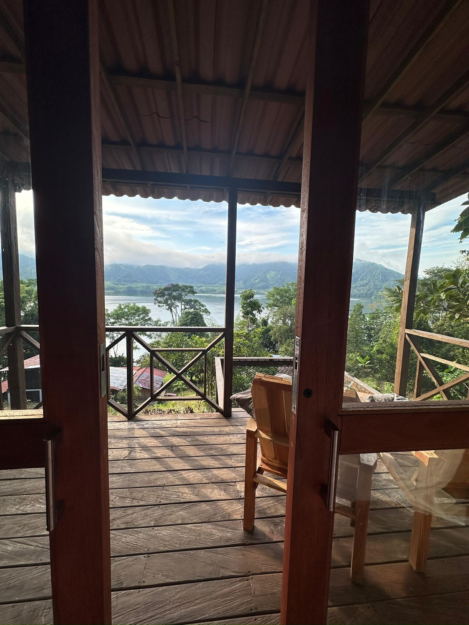 Eine Holzterrasse mit Blick auf einen See und Berge.