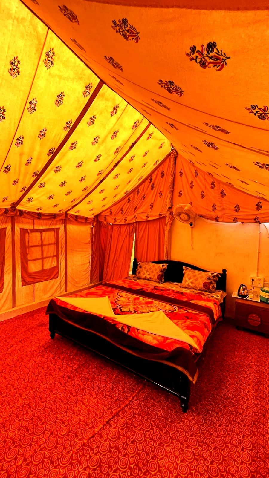 A tent-style room with a bed, curtains, and a window.