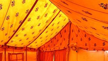 A tent-style room with a bed, curtains, and a window.