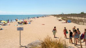 A beach with people sunbathing, umbrellas, and a sign indicating a monitored zone. - ⛱️ Direct beach access - 4* campsite All-comfort mobile home + Covered terrace (Vias)